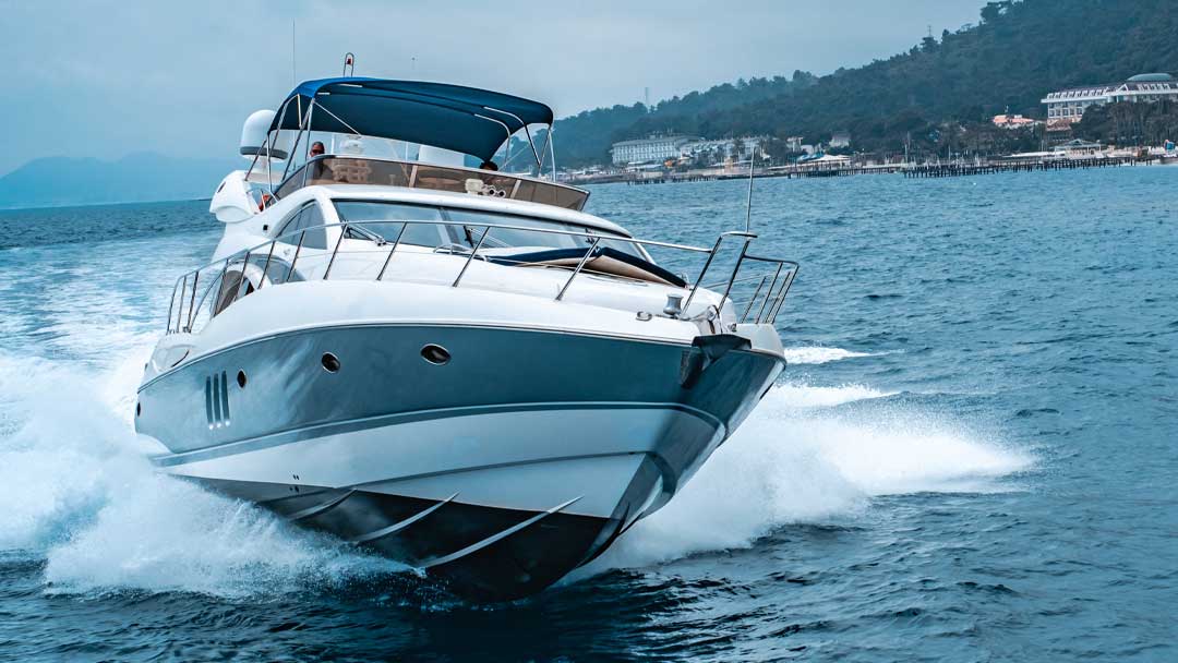 A yacht speeding across the water, with a clean hull due to ultrasonic antifouling.